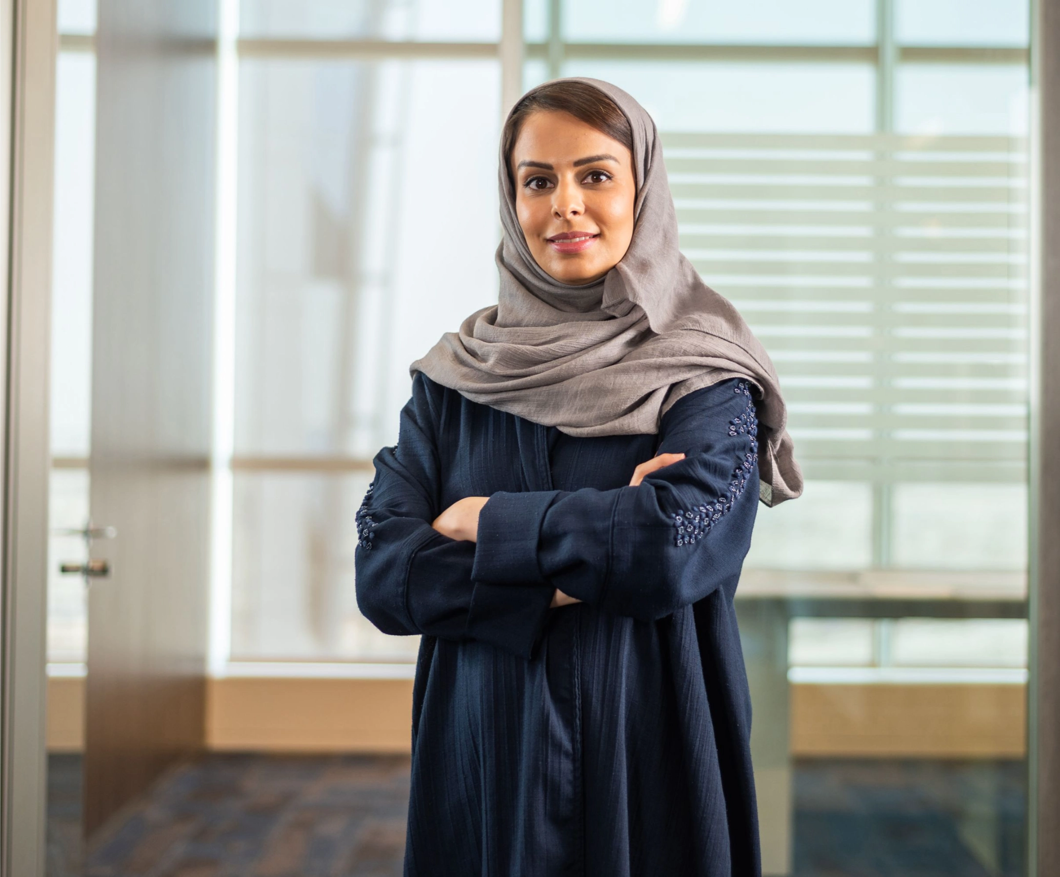 a woman wearing a head scarf and standing in a room
